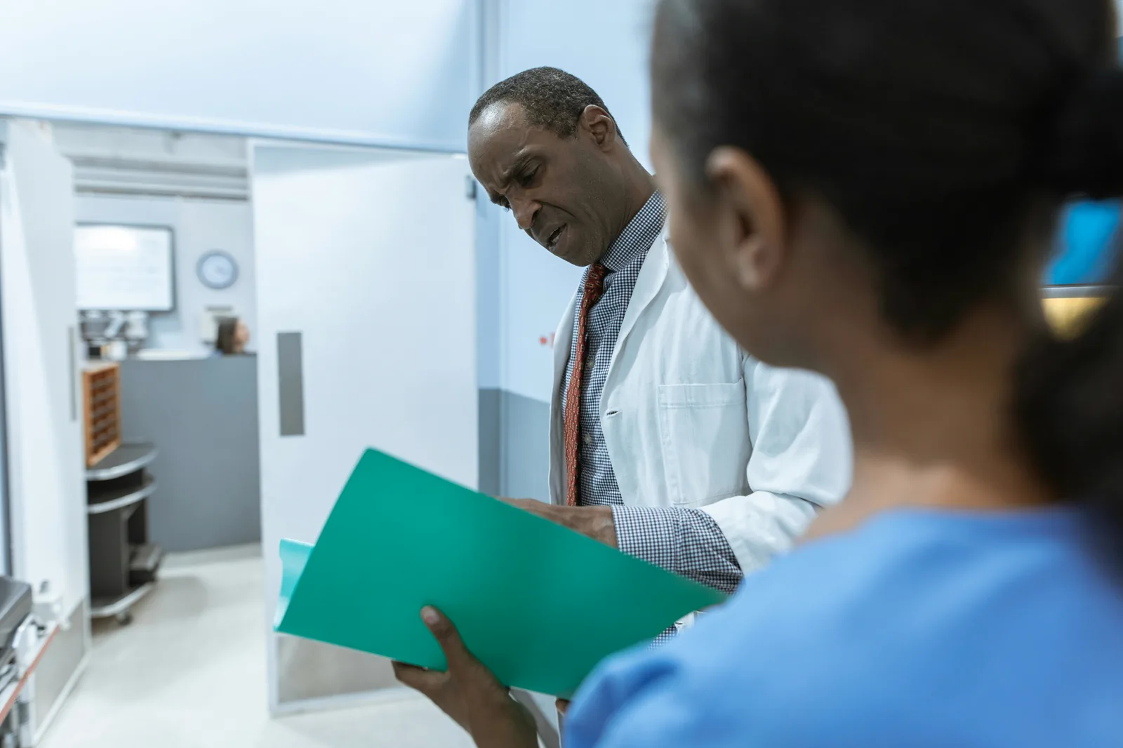 Doctor reviewing a patient folder during a follow-up consultation.