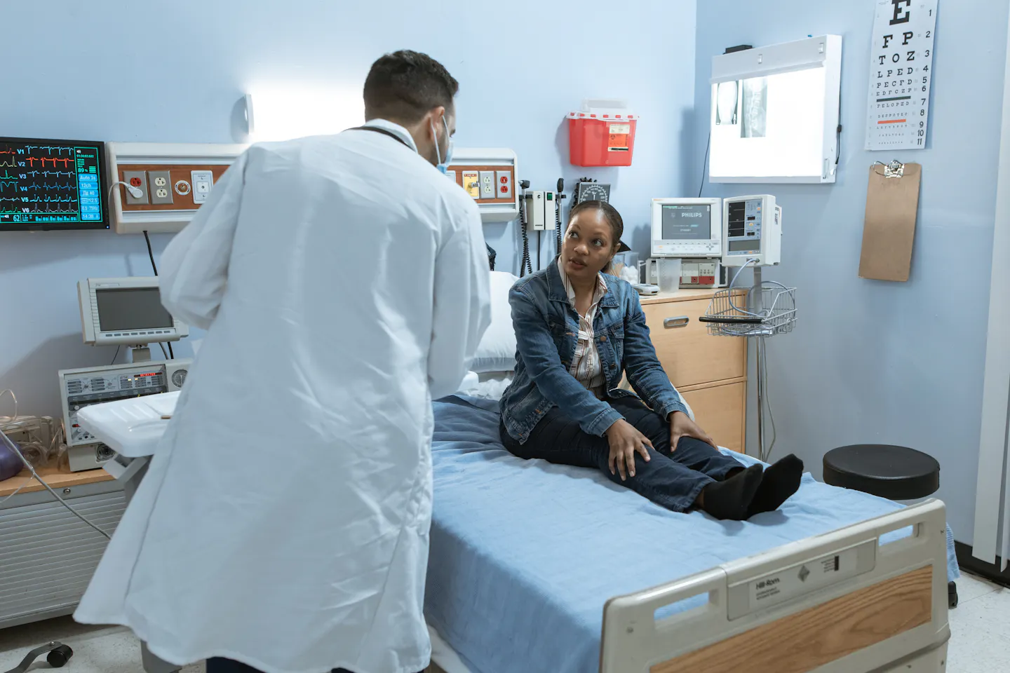 Doctor speaking with a patient in a hospital room after an accident evaluation.