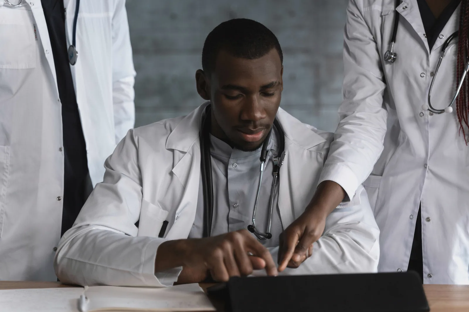 Doctors reviewing patient information on a tablet together.