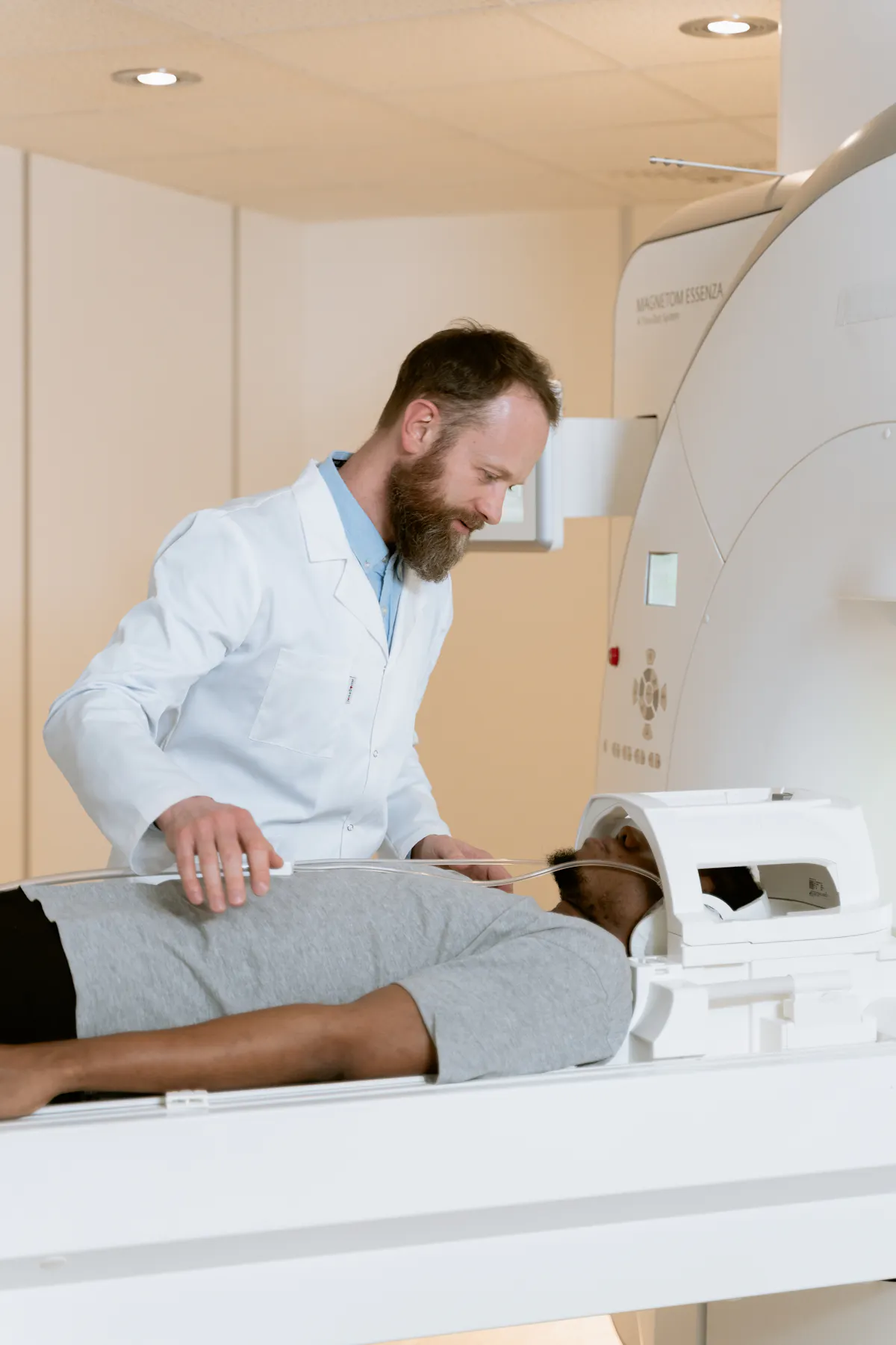 Patient positioned for an MRI scan with a clinician assisting nearby.